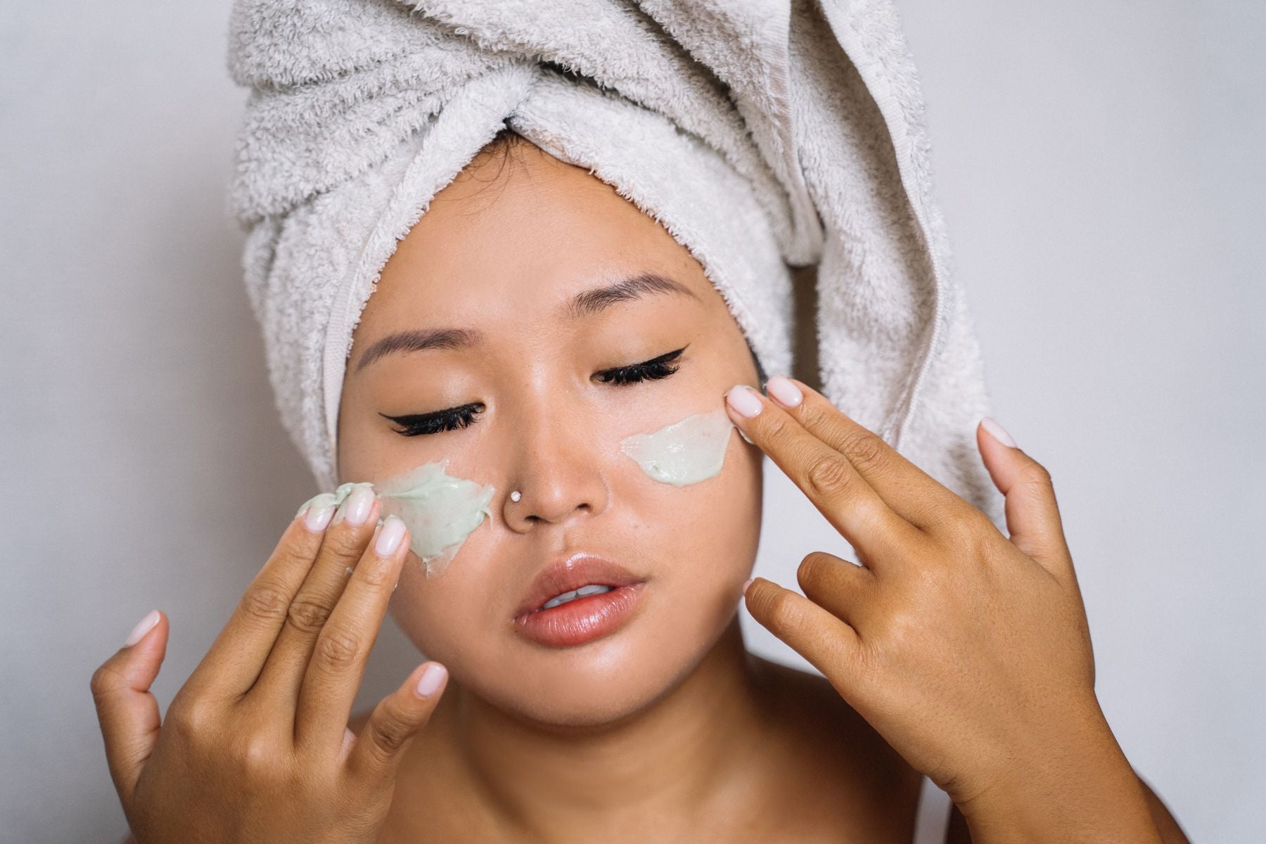 Mujer asiática aplicando mascarilla facial